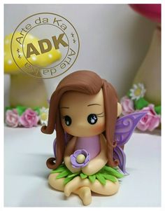 a small figurine sitting on top of a table next to a flower pot