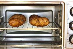 two potatoes are baking in an oven