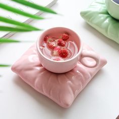 a small pink bowl with raspberries floating in it