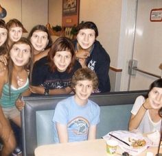 a group of young people sitting around a table