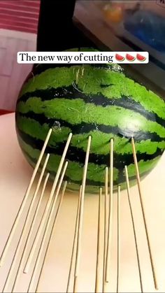 a large watermelon sitting on top of a table with sticks sticking out of it