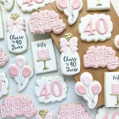 birthday cookies decorated with pink and white icing on a wooden platter for forty years