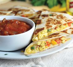 a plate topped with quesadillas and salsa