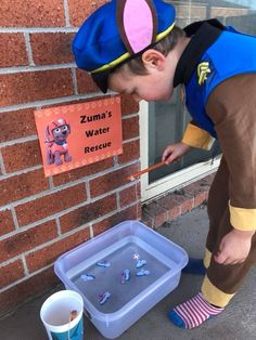 a young boy is playing with water outside