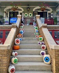 the stairs are decorated with fake eyes and pumpkins for halloween decorations in front of a house