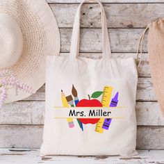 "Enter the following: 1. Teacher Name  For Example: 1. Mrs. Miller This cute colorful retro style tote bag is perfect for the new school year.  It's also the perfect gift for back to school teacher gift. This personalized print is printed on one side of the tote bag. Description: This 100% cotton canvas bag comes in one size - 15\" x 16\"- perfect for everyday wear. While the canvas material will show off the designs in great colors, it's durable and will last for years. The bag features 20\" handles (made from the same canvas), making it easy to carry even with a week's worth of shopping. Material: 100% cotton canvas with reinforced handle stitching for durability     Key features 100% Cotton canvas Made from spun fibers that make a very strong and durable fabric. Flat corners The front a Diy Teacher Tote Bag, Teacher Back To School Gifts, Leaving Gifts For Teachers, Teacher Appreciation Tote Bags, Teacher Tote Bag Gift, Teacher Canvas Bag, Teacher Presents, Personalized Teacher Appreciation T-shirt For Back To School, Teacher Canvas