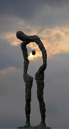 a statue is shown with the sun in the background