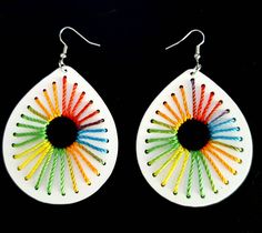 a pair of white earrings with multicolored sticks in the shape of a tear