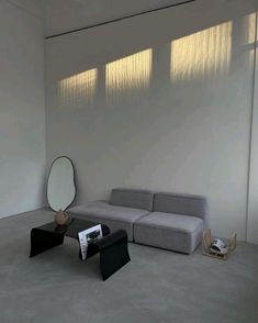 a living room with a couch, mirror and other items on the floor in front of a white wall