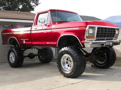 a red truck parked in front of a garage