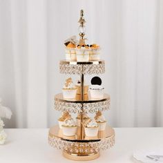 a three tiered cake stand with cupcakes and other desserts on it