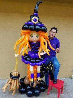 a statue of a girl with orange hair holding a broom and wearing a witch hat