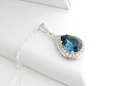 "This sparkly necklace has been made with a custom frame, only available in our shop! The rhodium plated frame has around 20 small clear cubic zirconias and the focal is a sparkly Montana Blue color Swarovski teardrop. This luxury necklace is perfect for a fancy night out, great as focal point of your outfit or for Bridesmaids gift. The swarovski teardrop crystal measures 18mm and the whole pendant including the Cubic Zirconia Drop setting about 1\" (25mm) in total length. Comes on a 18 inch ste Blue Wedding Necklace, Blue Gem Necklace, Blue Pendant Necklace, Sparkly Necklace, Navy Blue Wedding, Swarovski Necklace, Luxury Necklace, Blue Pendant, Luxury Diamonds