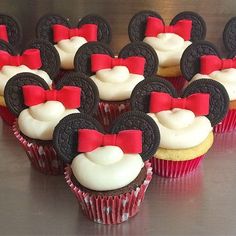 some cupcakes with red bows and oreos on them