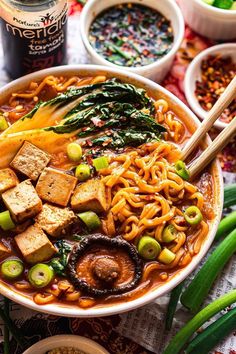 a bowl filled with noodles, vegetables and tofu