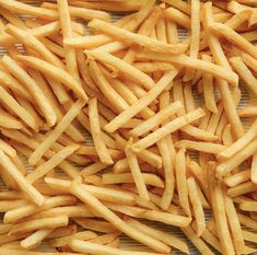 french fries are piled on top of each other in order to be cooked or eaten