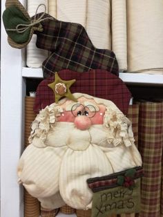 a santa clause doll sitting on top of a shelf next to some fabric and other items