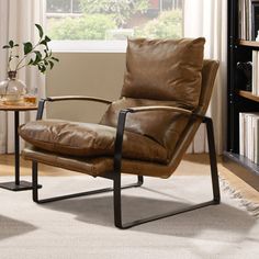 a brown leather chair sitting on top of a white rug next to a book shelf