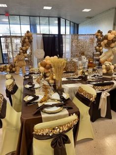 the tables are set up with brown and white tablecloths, gold decorations, and balloons