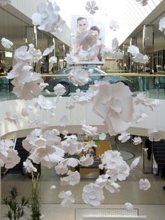 an overhead view of a shopping mall with paper flowers hanging from the ceiling