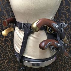 a mannequin's torso is adorned with leather and brass hardware