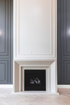 an empty fireplace in a room with gray walls and white trim on the mantles