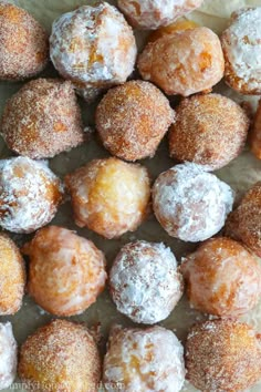 there are many different types of doughnuts on the paper bag and one is covered in powdered sugar