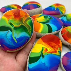 a hand is holding some colorful decorated cookies