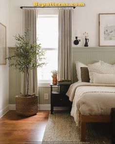 a bed room with a neatly made bed and a plant