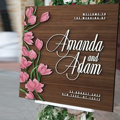 a wooden sign with pink flowers on it