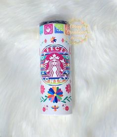 the starbucks cup is decorated with flowers and has a colorful logo on it's side