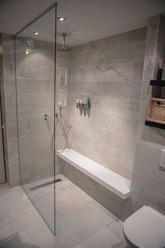 a bathroom with a glass shower door, toilet and bathtub next to the sink