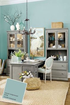 an office with blue walls and furniture in the room, including a desk, chair, cabinet