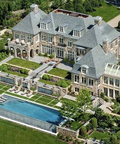 an aerial view of a large mansion with a pool in the middle and lots of windows