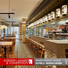 an empty restaurant with tables and chairs in front of the counter, along with hanging lights