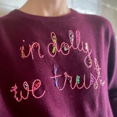 a close up of a person wearing a sweater with beads on it and the words i'm dolly true written in pink