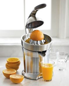 an orange is being squeezed into a juicer