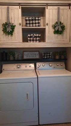 a white washer and dryer sitting next to each other in front of cabinets