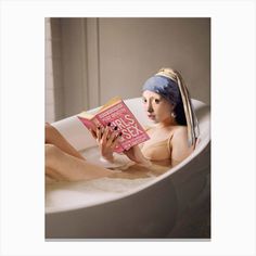 a woman with a towel on her head is sitting in a bathtub reading a book