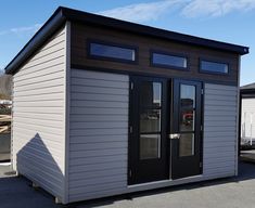 a small gray building with windows and doors