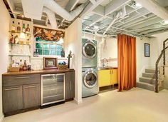 an industrial style laundry room with washer and dryer in the center, stairs leading up to the second floor