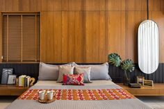 a bed sitting in the middle of a bedroom next to a mirror and wooden cabinets