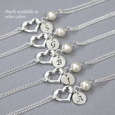 four personalized necklaces with hearts and initial charms on the sides, all in sterling