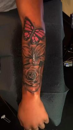 a woman's arm with a butterfly and rose tattoo on the left side of her leg