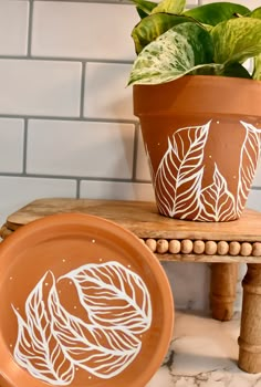 a potted plant sitting on top of a wooden table next to a ceramic plate