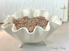 a bowl filled with lots of food on top of a white counter next to a cross