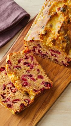 sliced loaf of fruit bread sitting on top of a wooden cutting board