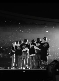 a group of young men standing on top of a stage in front of a crowd