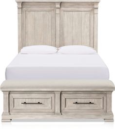 a white bed with two drawers underneath it