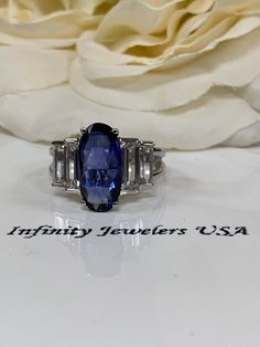 oval blue sapphire engagement ring, with elongated emerald cut white sapphires 14k white gold #5783 #GenuineDiamonds #OvalSapphire #14kWhiteGold #EngagementRing #BlueSapphireRing #LabCreatedSapphire #WeddingRing #LadiesRing #BlueSapphire #OvalCut Blue Emerald-cut Baguette Diamond Jewelry, Blue Baguette Cut Lab-created Sapphire Ring, Blue Sapphire Baguette Cut Ring In 14k White Gold, Silver Sapphire Ring With Baguette Diamonds, Emerald Cut, Blue Sapphire Engagement Ring, Elongated Oval, Blue Sapphire Necklace, Cushion Cut Ring, Sapphire Engagement Ring Blue